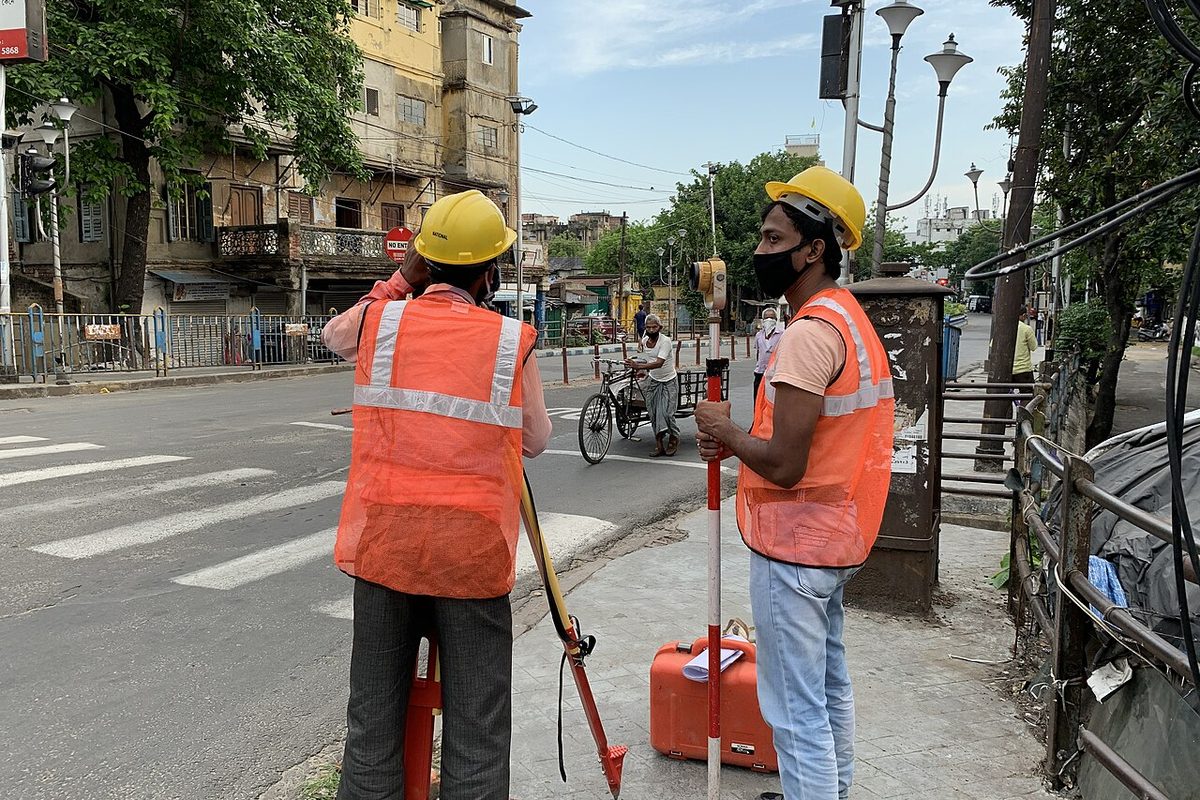 Topógrafos con casco y chaleco en una visita técnica de campo